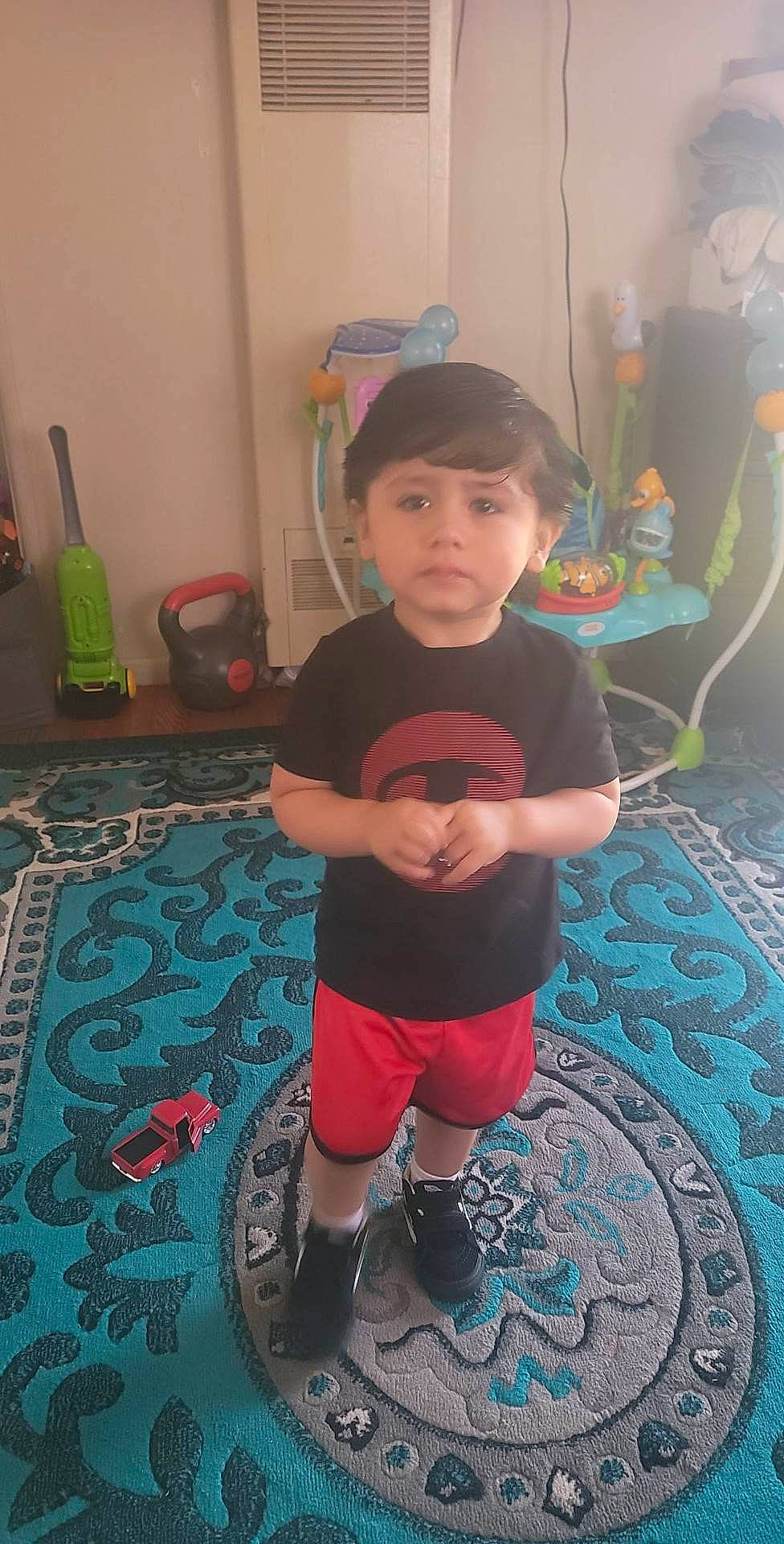 Eduardo is registered to the contest to win money with this photo: baseball_cap, cap, carpet, child, electric_blue, floor, flooring, fun, human_leg, knee, leisure, pattern, person, personal_protective_equipment, room, shorts, sportswear, t_shirt, thigh, toddler