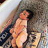 baby, infant, pillow, blanket, soft_toys, clothing, lying_down, indoors, cute, child, pink, nursery, cozy, resting, portrait, newborn, warm, furniture, sleepwear, mittens