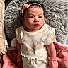 Ricah Olivia is registered to the contest to win money with this photo: baby, infant, child, pillow, blanket, clothing, mittens, headband, flower_pattern, pink, white, face, skin, cute, lying_down, indoor, soft_texture, portrait, newborn, expression