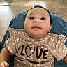 Hazel is registered to the contest to win money with this photo: baby, infant, child, portrait, smiling, sitting, indoor, close_up, face, eyes, hair, floral_clothing, dress, love, jeans, lap, home, wood_floor, natural_light, photography