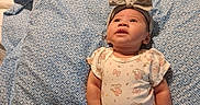 Hazel joined the competition — help win amazing prizes! baby, infant, child, portrait, lying_down, bed, bedding, pillow, onesie, headband, bow, floral_pattern, smiling, indoors, bedroom, clothing, fashion, cozy, photography, family