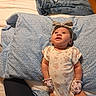 baby, infant, child, portrait, lying_down, bed, bedding, pillow, onesie, headband, bow, floral_pattern, smiling, indoors, bedroom, clothing, fashion, cozy, photography, family