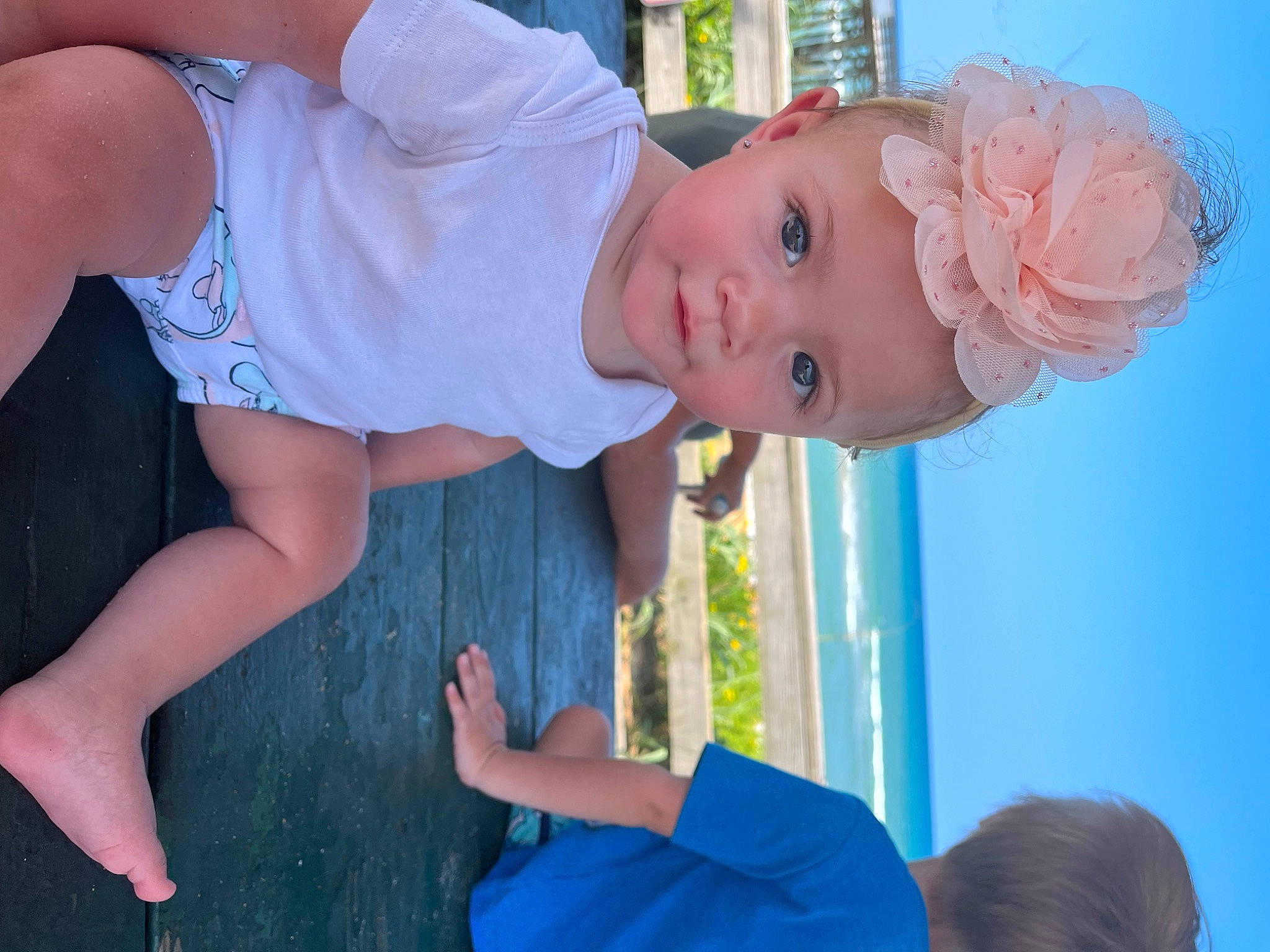 Brinley is registered to the contest to win money with this photo: arm, azure, baby_toddler_clothing, blue, child, electric_blue, finger, fun, gesture, grass, green, happy, joint, person, photograph, skin, sky, summer, thigh, toddler