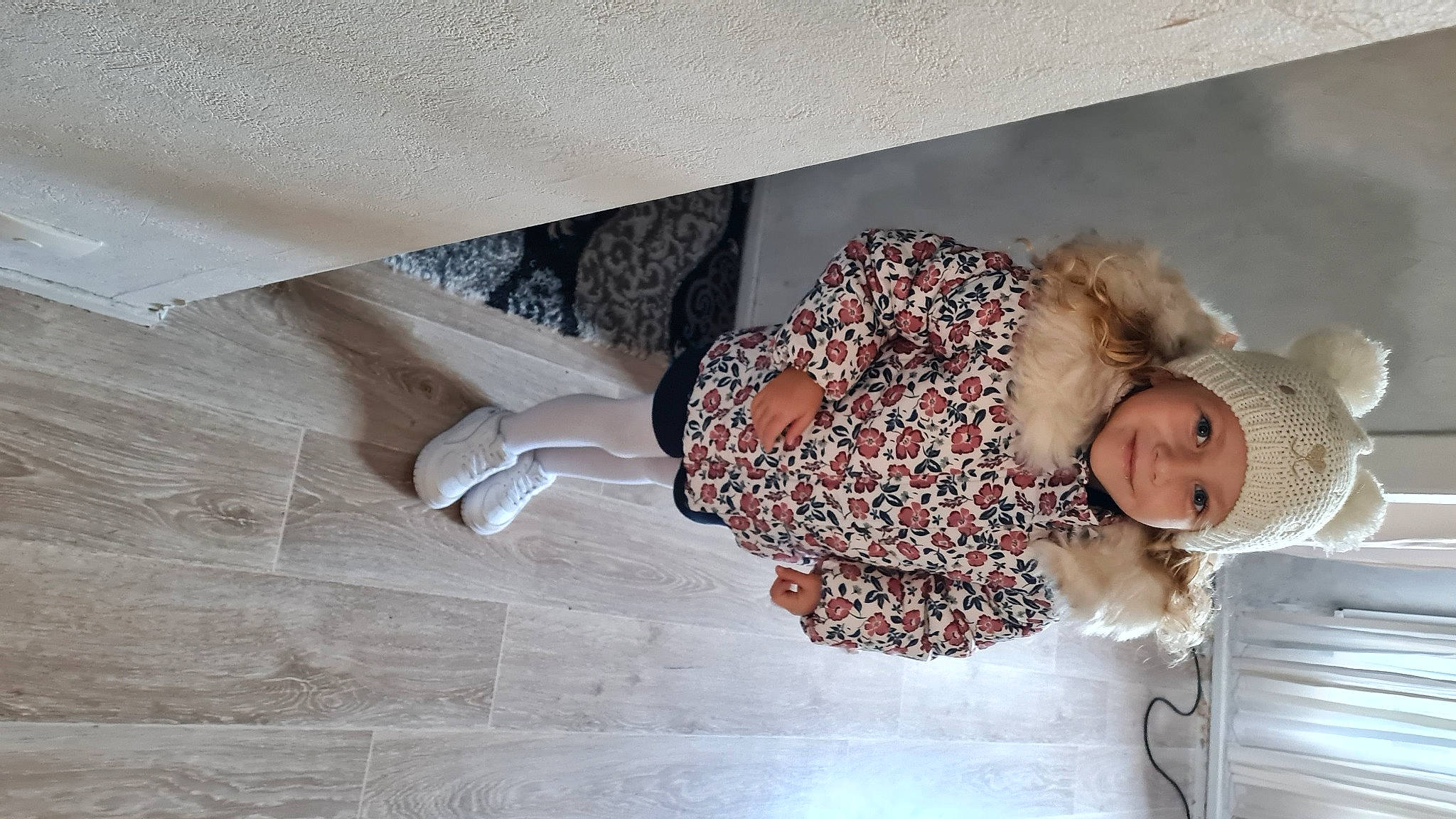Kélya participe au concours pour gagner de l'argent avec cette photo : baby, baby_toddler_clothing, comfort, floor, flooring, happy, hardwood, headwear, human_leg, joy, pattern, peach, person, room, sleeve, smile, thigh, toddler, waist, wood