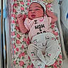 newborn, baby, infant, hospital, bassinet, floral_blanket, pink, clothing, hat, cute, lying_down, birth_announcement, baby_girl, face, person, pajamas, bed, hospital_room, newborn_clothes, portrait