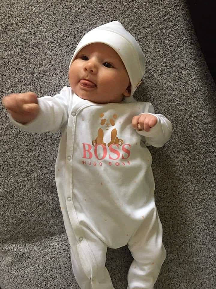 Angela participe au concours pour gagner de l'argent avec cette photo : arm, baby, baby_toddler_clothing, cap, cheek, child, chin, eye, finger, gesture, hand, happy, head, headgear, headwear, human_body, person, skin, sleeve, thumb