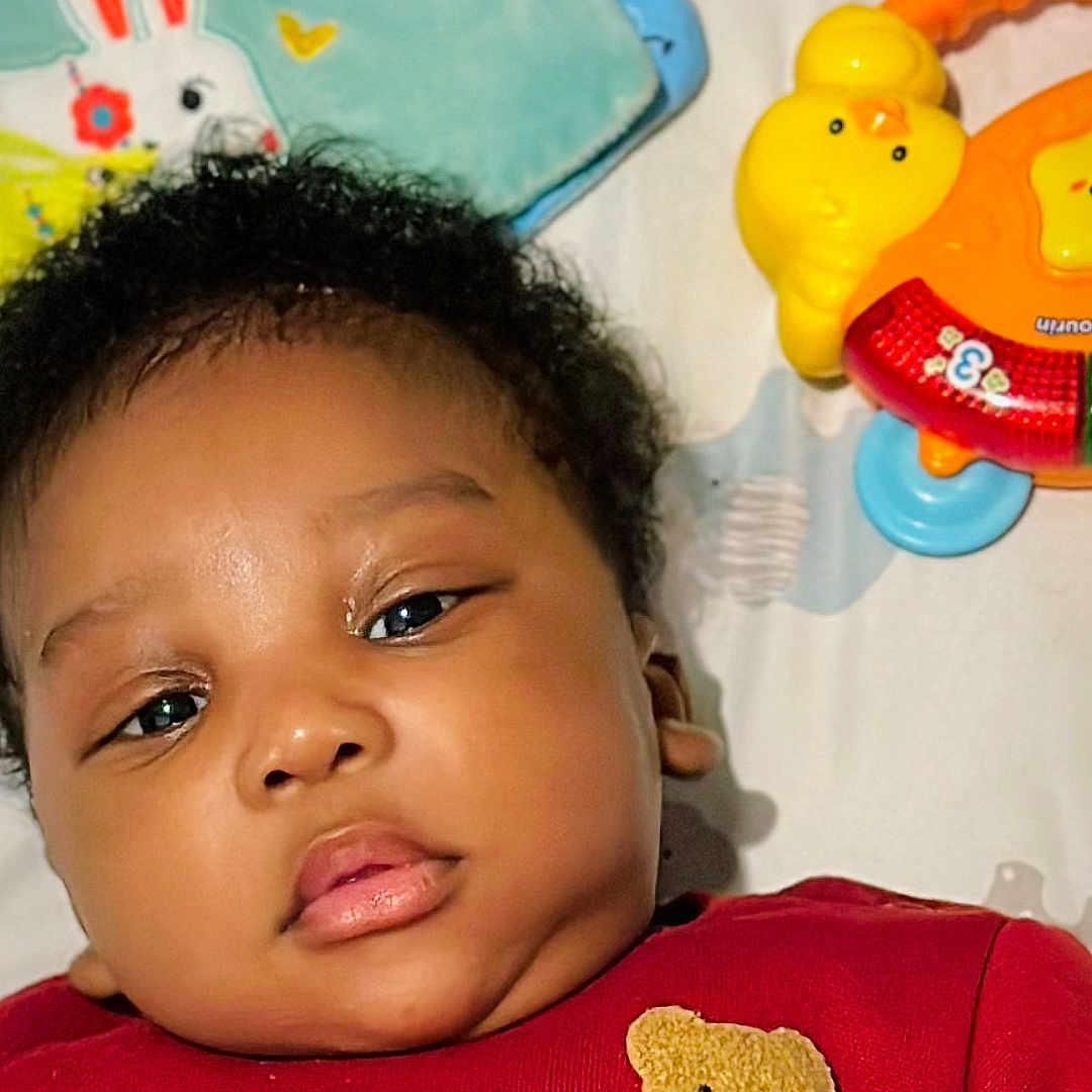 Eliott participe au concours pour gagner de l'argent avec cette photo : baby, blanket, bunny, child, chubby_cheeks, close_up, cute, face, indoors, infant, lying_down, peaceful, plush, portrait, red_clothing, soft_toys, stuffed_animal, toy, yellow_toy, young_child