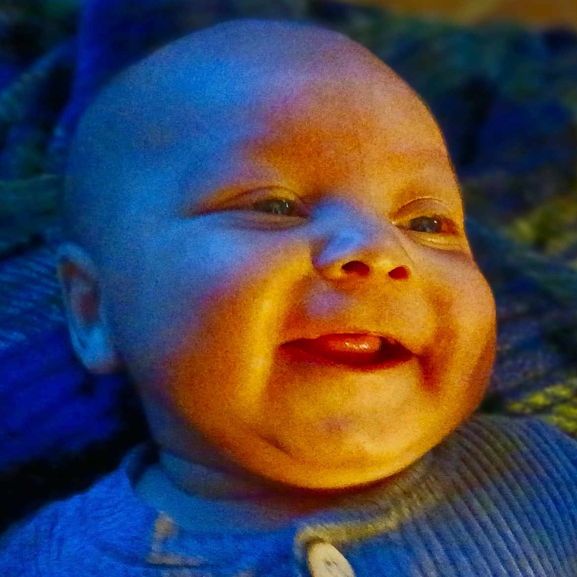 Zy'Iir joined the competition — help win amazing prizes! baby, blanket, blue_clothing, child, closeup, cool_light, cute, expression, face, happy, head, indoors, infant, portrait, skin, smile, texture, tongue, warm_light, young