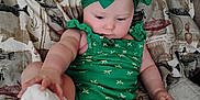 Zelpa joined the competition — help win amazing prizes! baby, child, green_outfit, headband, sock, couch, blanket, indoor, curious, sitting, infant, cute, plush, patterned_blanket, soft_lighting, arm, leg, foot, face, person