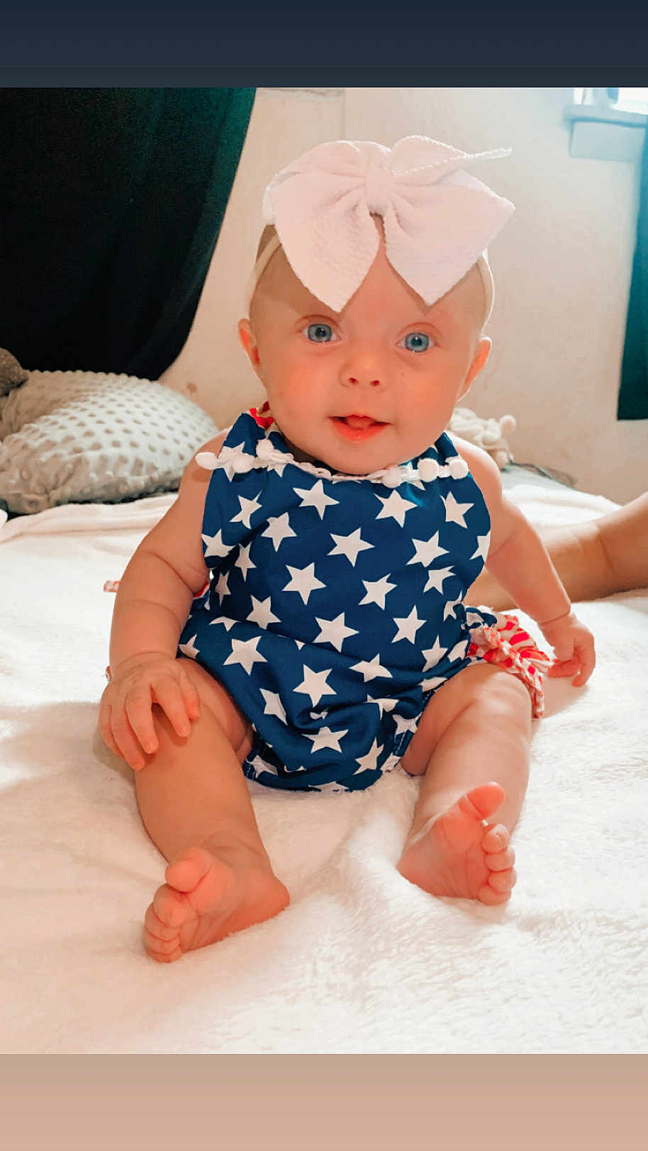 Lakelynn joined the competition — help win amazing prizes! baby, child, blue_eyes, bow, star_pattern, sitting, blanket, pillow, indoor, cute, infant, person, soft_light, white_blanket, headband, smiling, toes, hand, cozy, portrait