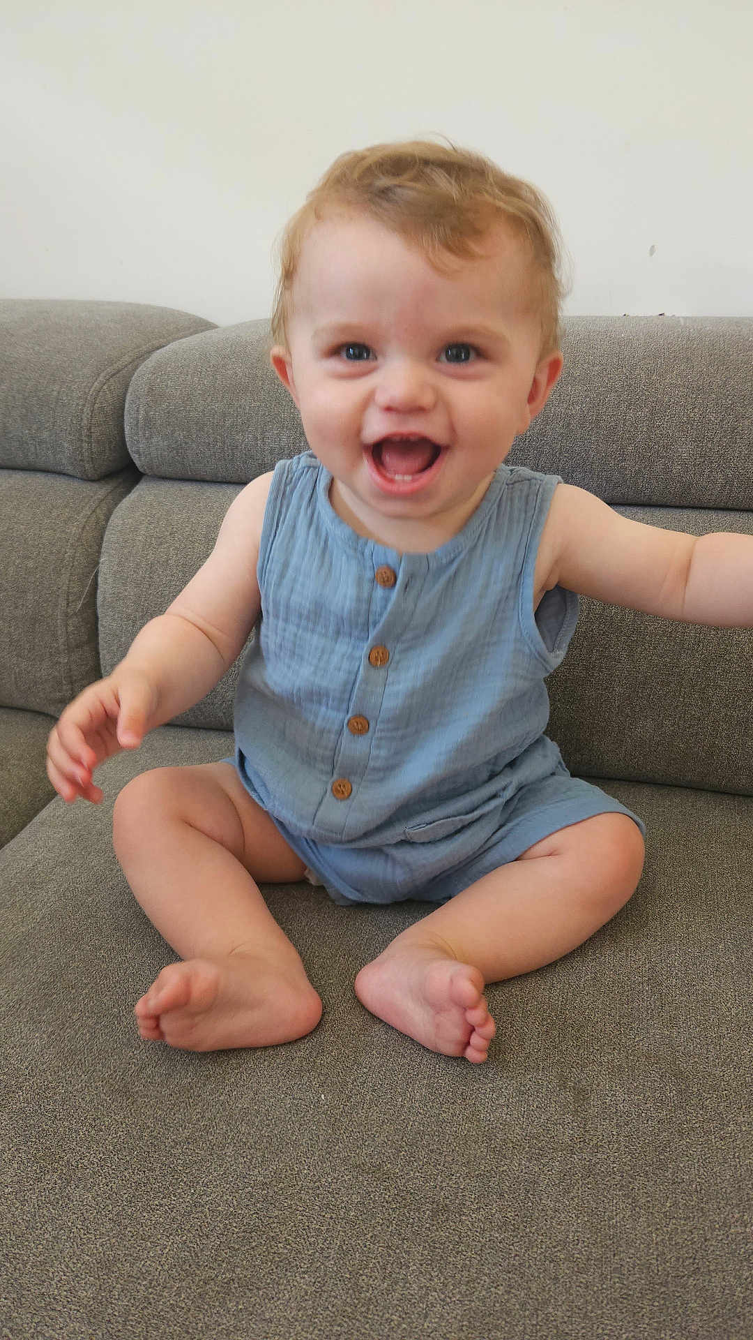 Maël a rejoint le concours — aidez-le/la à gagner de superbes lots ! baby, child, smile, happy, sitting, romper, blue_clothing, couch, furniture, indoor, cute, infant, face, skin, arm, foot, toes, eyes, head, person