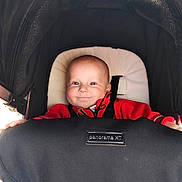 Harrison joined the competition — help win amazing prizes! baby, stroller, infant, child, smiling, face, black_canopy, red_clothing, seatbelt, happy, person, portrait, baby_carrier, cute, indoors, head, young_child, comfort, transportation, closeup