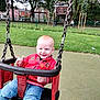 Harrison joined the competition — help win amazing prizes! toddler, child, swing, playground, park, grass, trees, red_hair, smiling, jacket, jeans, outdoor, daytime, fence, person, play, happy, fun, seat, chains