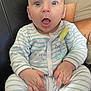 Elio participe au concours pour gagner de l'argent avec cette photo : baby, infant, striped_pajamas, blue_eyes, surprised_expression, sitting, couch, leather_couch, person, child, hand, face, clothing, casual, indoor, portrait, cute, young_child, parent, arm
