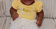 Blessing is registered to the contest to win money with this photo: baby, child, infant, smiling, portrait, yellow_outfit, headband, bow, butterflies, leggings, shoes, seated, quilted_background, indoor, close_up, happy, fashion, baby_clothing, dark_skin, adorable