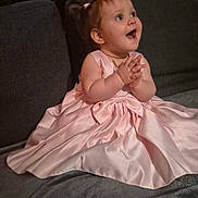 Alycia participe au concours pour gagner de l'argent avec cette photo : baby, child, pink_dress, clapping, couch, happy, smiling, indoor, portrait, cute, young_child, sitting, fabric, home, person, small_hands, joy, celebration, hairband, excitement
