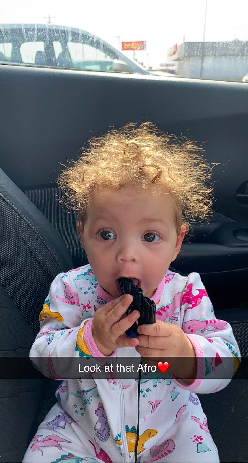 Ariannah is registered to the contest to win money with this photo: auto_part, automotive_exterior, baby, baby_toddler_clothing, car_seat, cheek, child, chin, drinkware, event, family_car, fun, hair, luxury_vehicle, motor_vehicle, nose, person, sitting, surprise, toddler