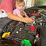 Ellieanna joined the competition — help win amazing prizes! toddler, child, adult, car, engine, mechanic, tools, hand, wristwatch, bracelet, garage, curious, person, vehicle, hood, motor, clothing, outdoor, repair, exploration