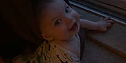Emmett is registered to the contest to win money with this photo: baby, infant, crawling, onesie, shark_pattern, curtain, door, glass_door, hose, indoor, carpet, smiling, child, face, hand, window, dark, cozy, floor, home