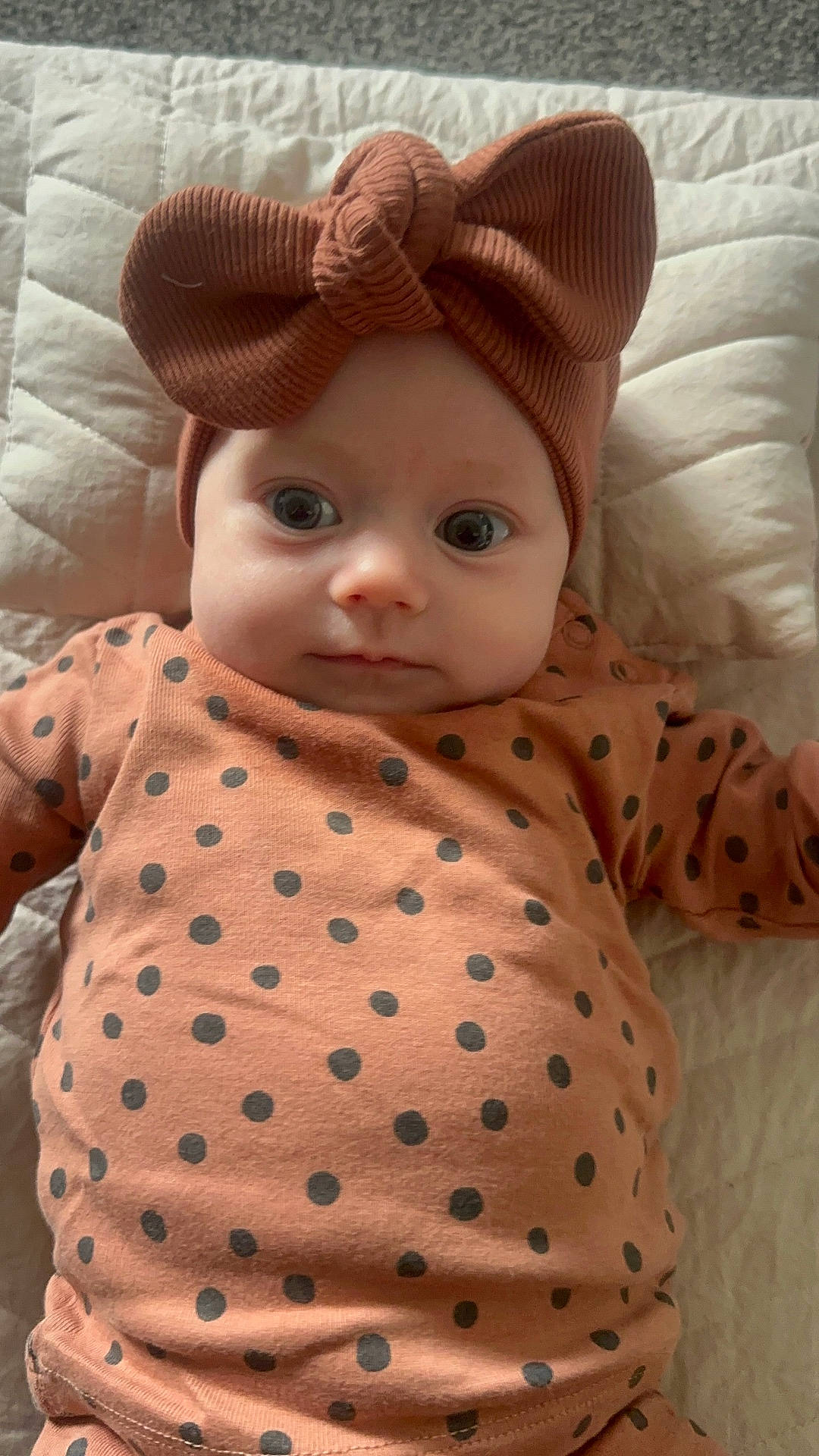 Olive joined the competition — help win amazing prizes! apparel, baby, bow, child, clothing, cute, expression, eyes, fabric, face, headband, indoors, infant, laying_down, newborn, person, polka_dot, portrait, quilt, soft
