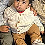Azriel is registered to the contest to win money with this photo: toddler, child, sweater, pants, shoes, sitting, indoor, curly_hair, brown_eyes, three_children, hand, couch, cozy, knitwear, casual_clothing, portrait, family, warm_lighting, closeup, expression
