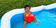 Azriel joined the competition — help win amazing prizes! toddler, child, pool, inflatable_pool, water, grass, outdoor, smiling, sitting, toy, bottle, car, vehicle, parking, curly_hair, summer, play, blue, white, privacy_emoji