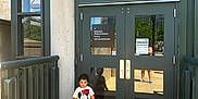 Azriel is registered to the contest to win money with this photo: building, child, concrete, daylight, door, garden, glass, mickey_mouse, museum, outdoor, parking, person, railing, reflection, sandals, shadow, shorts, sign, toddler, tshirt