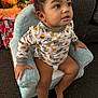 toddler, child, pajamas, chair, plush_chair, christmas_tree, presents, holiday, indoor, carpet, curly_hair, cute, smiling, clothing, furniture, home, decorations, holiday_lights, person, sitting
