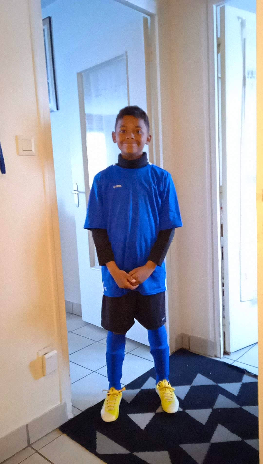 Sulyvann a rejoint le concours — aidez-le/la à gagner de superbes lots ! active_shorts, bermuda_shorts, child, door, electric_blue, flooring, fun, human_leg, joy, knee, leg, person, personal_protective_equipment, shoe, shorts, sleeve, smile, sportswear, sweatpant, t_shirt