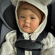 Cairo is registered to the contest to win money with this photo: child, toddler, baby, car_seat, seatbelt, buckle, hood, beanie, fleece, winter_clothing, cozy, rosy_cheeks, portrait, closeup, car_interior, cute, expression, infant, safety, warmth