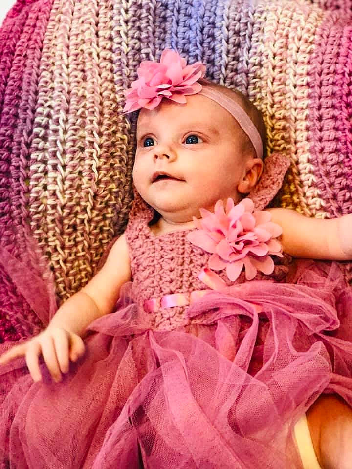 Paislee is registered to the contest to win money with this photo: baby, baby_toddler_clothing, cheek, chin, dress, eye, eyebrow, eyelash, flower, hand, head, headgear, headwear, iris, lip, outerwear, person, petal, pink, skin