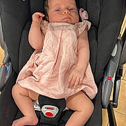 Jade a rejoint le concours — aidez-le/la à gagner de superbes lots ! baby, infant, car_seat, pink_dress, pacifier, bracelet, footwear, child, seatbelt, indoor, floor_tiles, black_fabric, cute, person, newborn, resting, portrait, skin, hand, foot