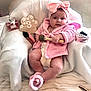 baby, infant, pink_robe, headband_bow, bow, diaper, makeup_brush, perfume_bottle, high_heel, milestone_sign, necklace, pillow, blanket, sitting, chubby_legs, cozy, portrait, adorable, rosy_cheeks, soft_fabric