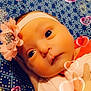 accessories, baby, bodypart, bonnet, clothing, face, finger, flower, flowerarrangement, flowerbouquet, hand, hat, head, headband, newborn, person, petal, photography, plant, portrait