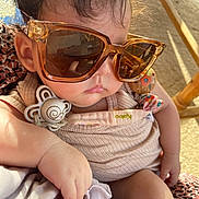Nour participe au concours pour gagner de l'argent avec cette photo : baby, child, sunglasses, pacifier, hand, face, clothing, indoor, light, shadow, skin, closeup, infant, comfort, relaxing, accessory, fabric, pattern, person, cute