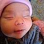 baby, sleeping, close_up, face, hat, pink, grey_clothing, soft_texture, infant, peaceful, child, portrait, cute, adorable, resting, young_child, warm, indoor, human, wearing