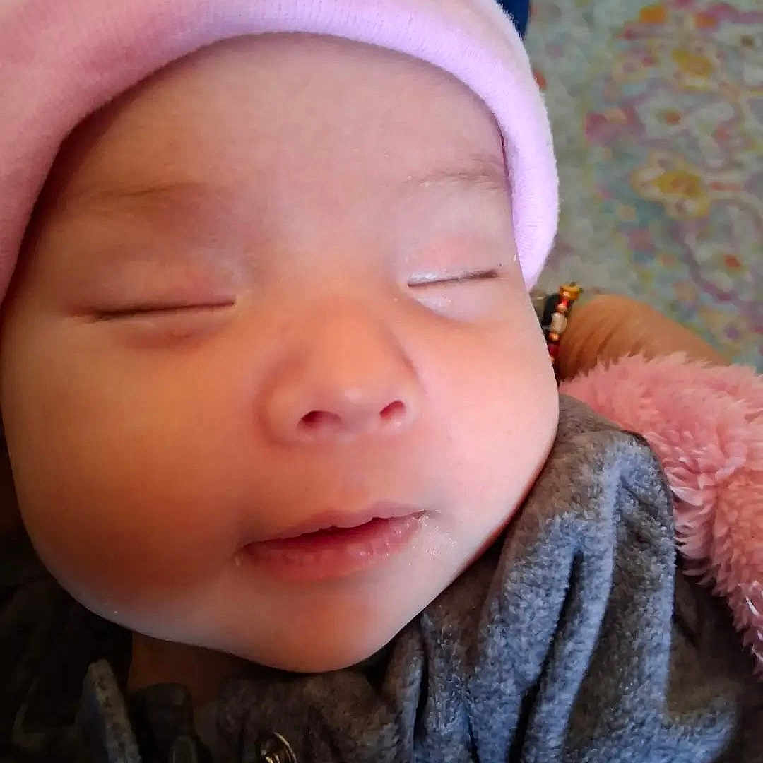 Bella joined the competition — help win amazing prizes! adorable, baby, child, close_up, cute, face, grey_clothing, hat, human, indoor, infant, peaceful, pink, portrait, resting, sleeping, soft_texture, warm, wearing, young_child