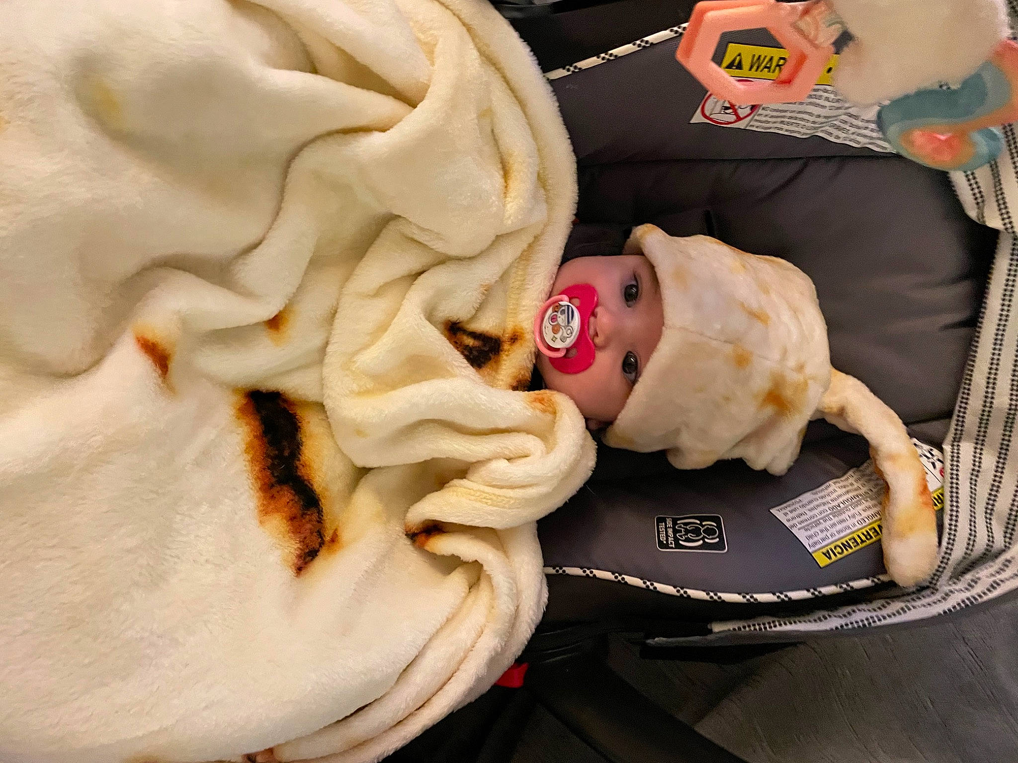 Mira is registered to the contest to win money with this photo: baby, baby_carriage, baby_products, baby_safety, baby_sleeping, baby_toddler_clothing, bag, carmine, child, comfort, doll, fawn, head, headwear, infant_bed, linens, orange, person, plush, stuffed_toy