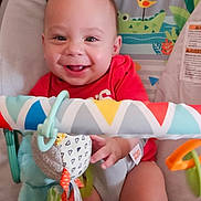 Leo is registered to the contest to win money with this photo: animal_prints, baby, baby_seat, child, colorful, cute, fabric, face, hands, happy, indoor, infant, legs, person, playful, playtime, seat, smiling, toddler, toy