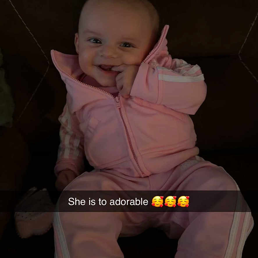 Paisley joined the competition — help win amazing prizes! baby, child, smiling, pink_clothing, sitting, couch, footwear, happy, indoor, portrait, face, young_child, cute, casual_wear, shoes, sneakers, text_overlay, snapchat, infant, cozy