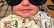 Paisley is registered to the contest to win money with this photo: animal_print, apparel, baby, child, closeup, clothing, cute, eyewear, face, fashion, happy, head, indoor, infant, onesie, person, portrait, smile, sunglasses, young