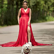 Teddy is registered to the contest to win money with this photo: dog, white_dog, running, happy, pet, outdoor, road, woman, red_dress, blurred_background, nature, forest, sunlight, joyful, animal, playful, summer, walking, fashion, portrait