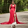 dog, white_dog, running, happy, pet, outdoor, road, woman, red_dress, blurred_background, nature, forest, sunlight, joyful, animal, playful, summer, walking, fashion, portrait