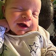 Abby joined the competition — help win amazing prizes! baby, child, closeup, cozy, cushion, cute, fabric, face, hand, indoor, infant, newborn, onesie, peaceful, portrait, resting, sleeping, smiling, soft_lighting, star_pattern