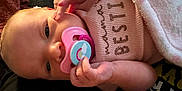 Abby is registered to the contest to win money with this photo: baby, pacifier, blanket, clothing, hand, face, infant, newborn, cute, soft, cozy, pink, text, sweater, person, portrait, skin, closeup, resting, child