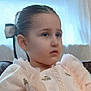 Prayla is registered to the contest to win money with this photo: child, girl, portrait, dress, bow, hair, earrings, indoor, soft_lighting, face, serious_expression, fashion, young, sitting, closeup, decorative, elegant, window, couch, background