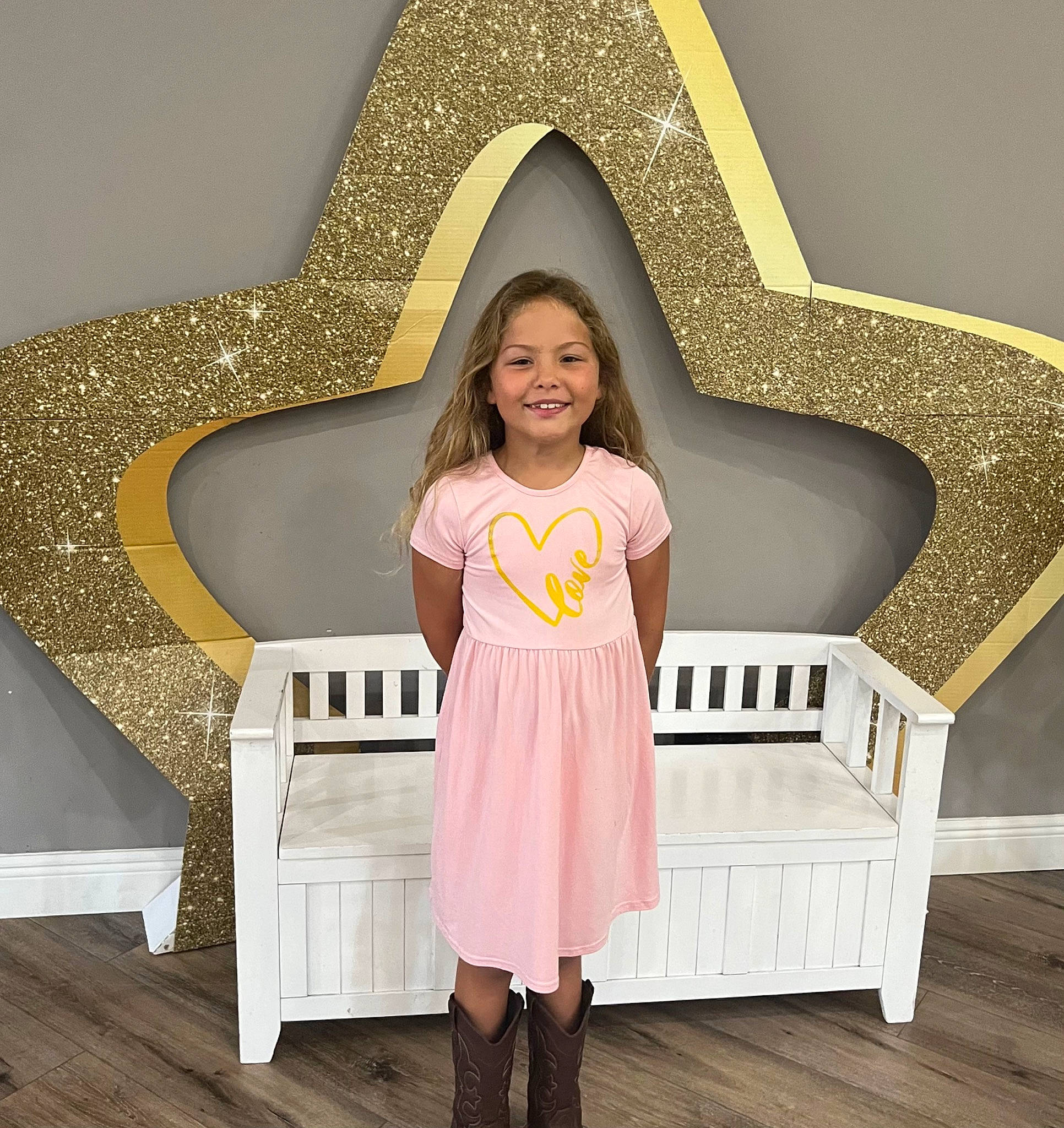 Ariel is registered to the contest to win money with this photo: baby_toddler_clothing, comfort, dress, floor, flooring, hair, hairstyle, happy, hardwood, interior_design, joy, leisure, line, organ, person, rectangle, sleeve, smile, waist, white