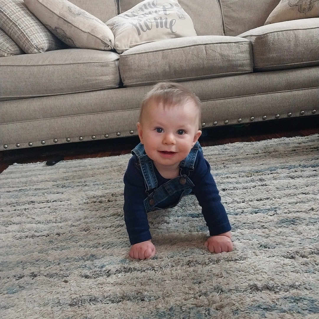 James is registered to the contest to win money with this photo: architecture, baby, babycrawling, building, clothing, couch, crawling, cushion, face, furniture, head, homedecor, indoors, jeans, livingroom, pants, person, photography, portrait, room