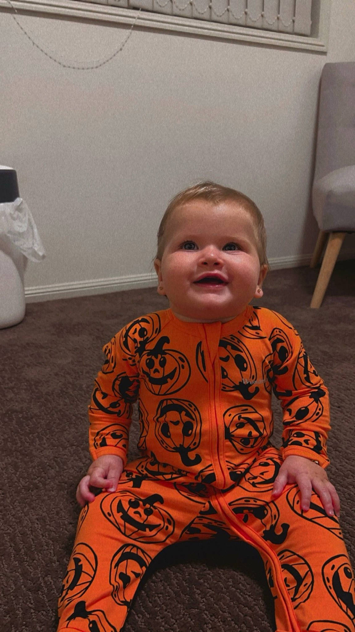 Macy is registered to the contest to win money with this photo: baby, baby_toddler_clothing, cheek, child, chin, comfort, floor, flooring, fun, head, nose, person, room, sitting, skin, sleeve, smile, standing, toddler, white