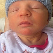 Rowan is registered to the contest to win money with this photo: newborn, baby, sleeping, hat, knit_hat, onesie, infant, closeup, face, peaceful, soft, cute, child, portrait, skin, headwear, small, resting, indoors, person